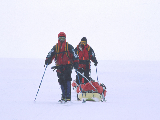 Clásica imagen avanzando por la meseta de hielo: en fila, cada uno con su trineo y sin visibilidad